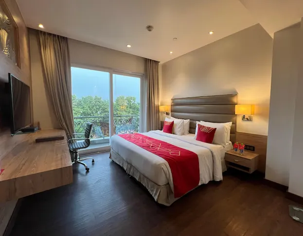 Deluxe room at Ramada By Wyndham Aligarh GT Road Agra featuring larger layout, modern furnishings, and seating space