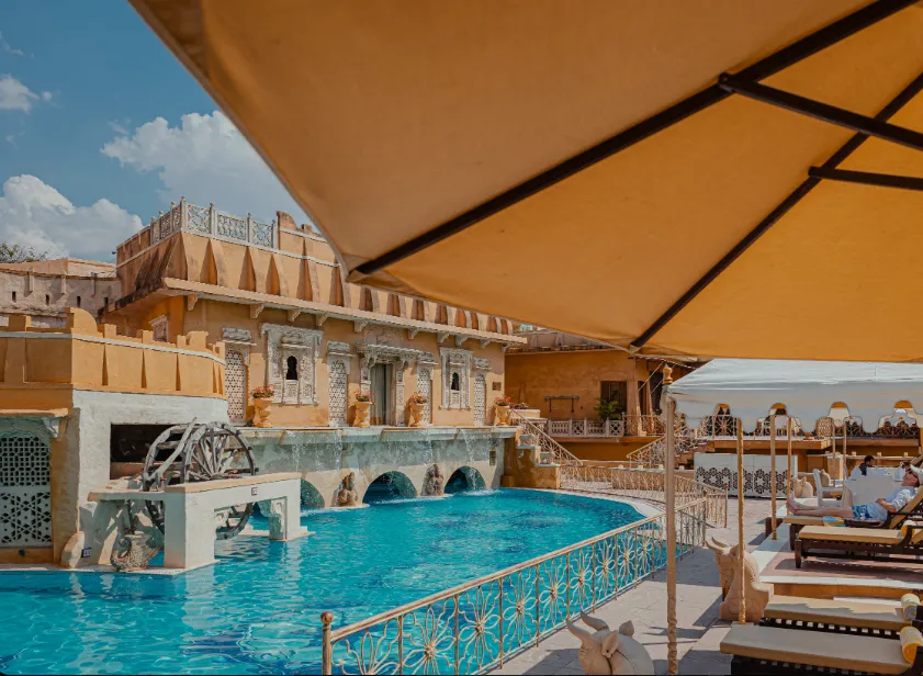 Swimming pool at Ajit Bhawan - A Heritage Resort Jodhpur with pool deck and surrounding seating