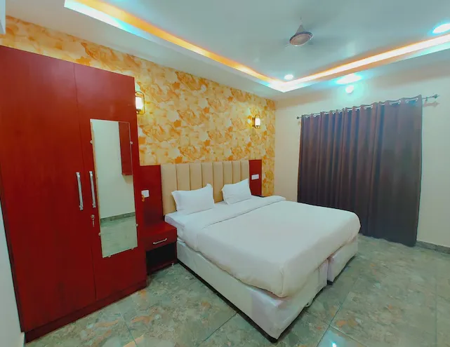 Deluxe room at Avadh Samrat Resort Ayodhya with larger layout, seating area, and window lighting