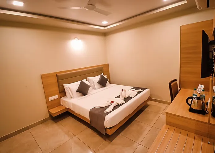 Deluxe room at Clarks Inn Express Udaipur with double bed, seating chair, and soft lighting