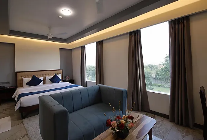Deluxe room at ClarksInn Suites Jaipur with wide layout, bedding, and seating space