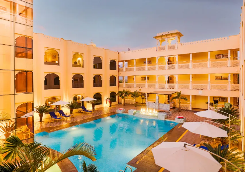 Swimming pool at Club Mahindra Resort Udaipur with open deck and poolside seating