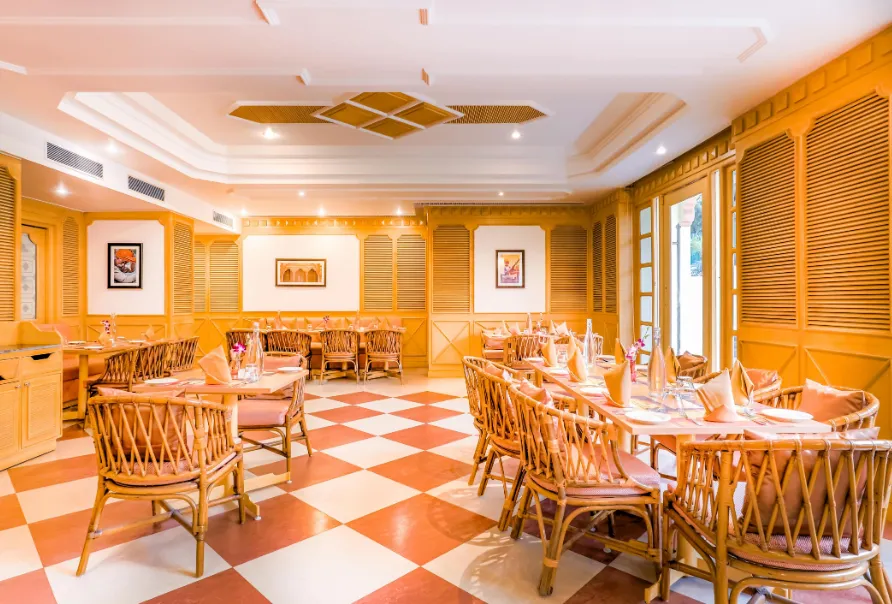 Restaurant at Club Mahindra Jaipur showing dining tables and indoor décor