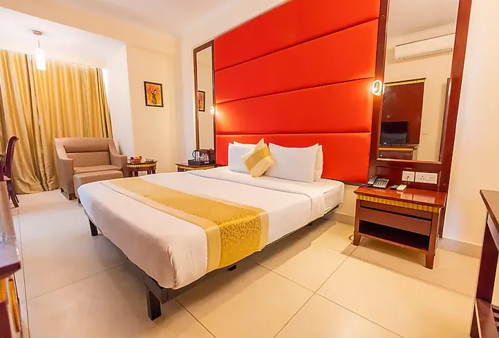 Deluxe room at Crestmont Ashapurna Jaipur showing spacious layout with seating and warm lighting