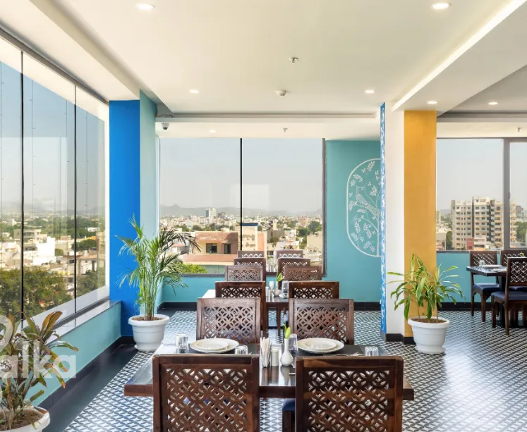 Restaurant area at Dé glance Udaipur showing dining tables and interior decor
