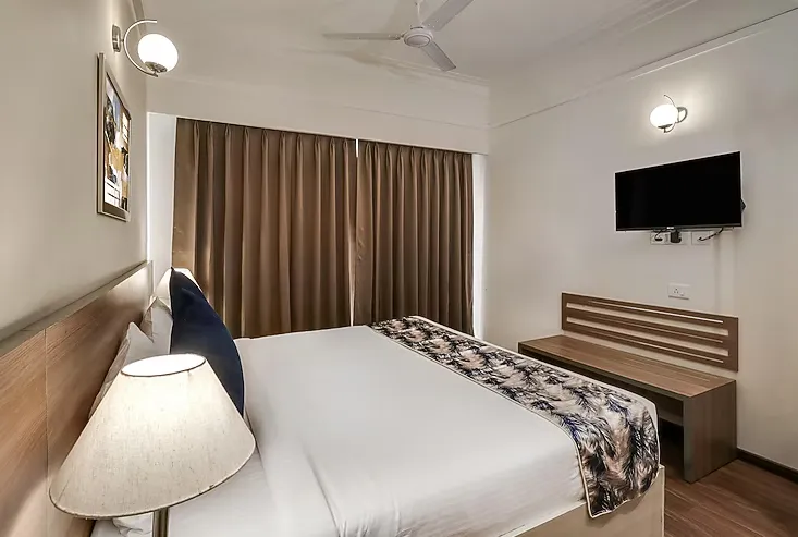 Deluxe room interior at Starlit Suites, Kolkata with workspace and elegant furnishings