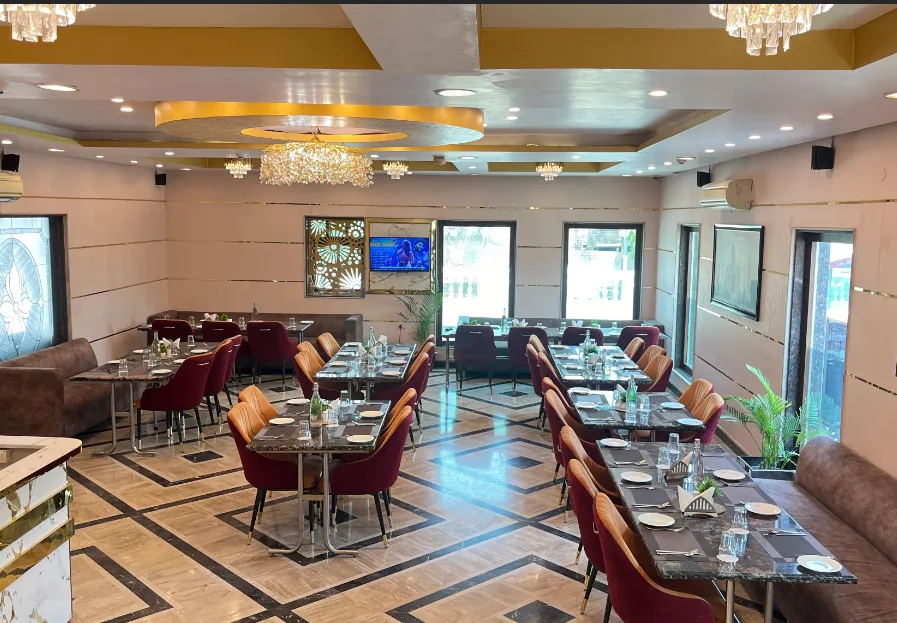 Restaurant at Foxoso Taj View Agra with dining tables, chairs, and ambient interior lighting