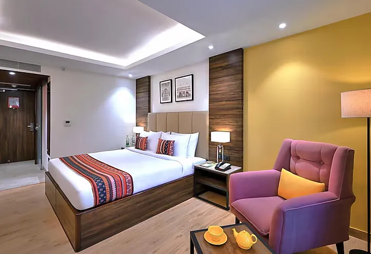 Deluxe room at Golden Tulip Agra with additional seating, window view, and modern room décor