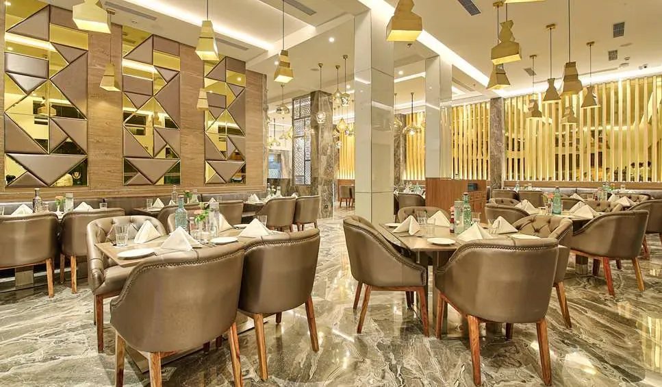 Restaurant at Golden Tulip Essential Jaipur showing dining tables and contemporary interior layout