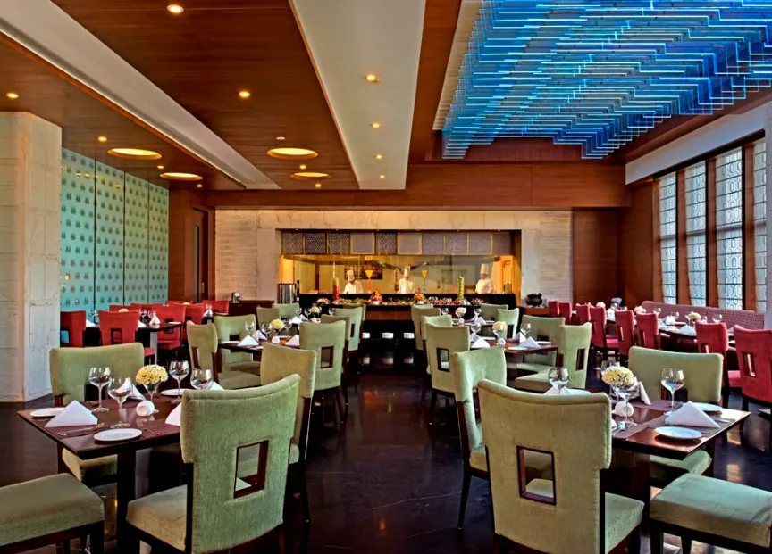 Restaurant at Golden Tulip Lucknow showing dining tables, chairs, and styled interior décor
