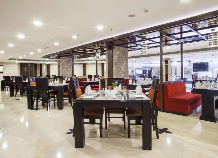 Restaurant at Golden Tulip Jaipur showing dining tables, interior décor, and service layout