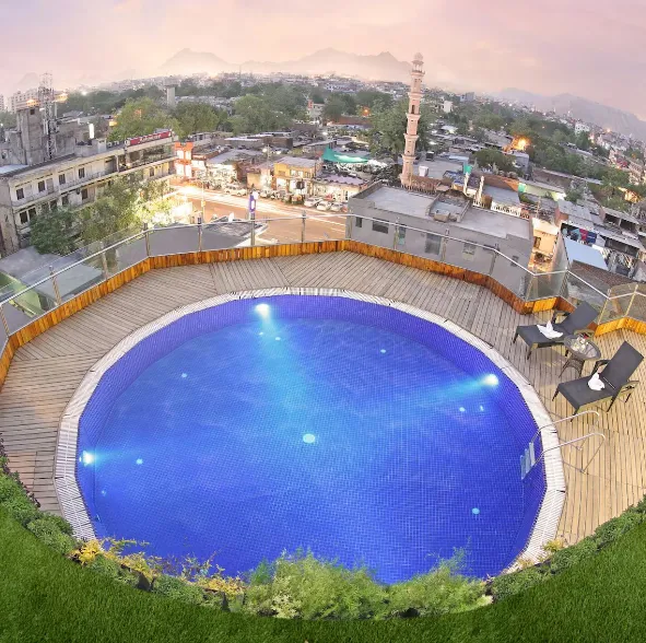 Rooftop swimming pool at Golden Tulip Jaipur with city views and poolside seating