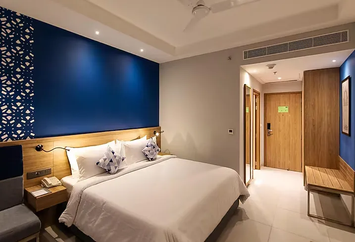 Premium room at Hometel Alambagh Lucknow with comfortable bed and practical room layout