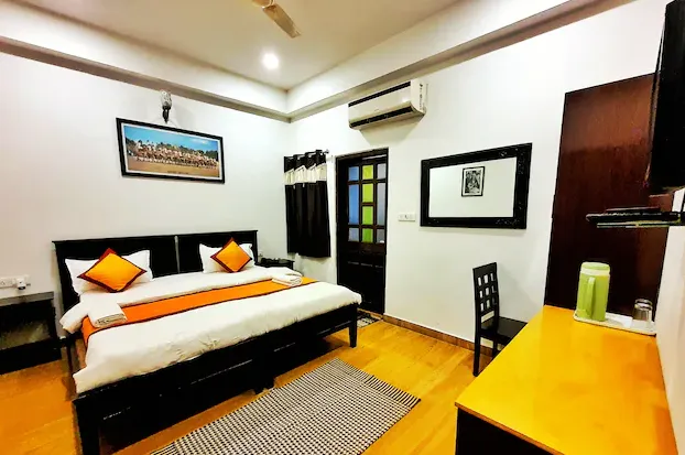Deluxe room at Hotel Ajanta Haveli Jaisalmer featuring spacious bed and simple décor