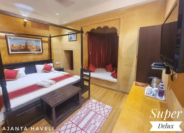 Deluxe room at Hotel Ajanta Haveli Jaisalmer featuring spacious bed and simple décor
