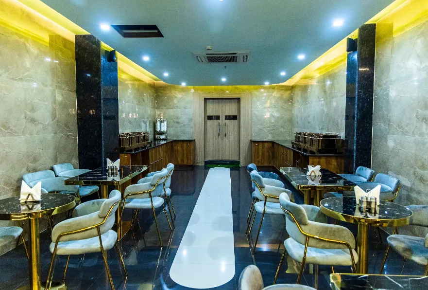Restaurant at Hotel Aryavilas Mathura displaying dining tables, lighting, and interior décor