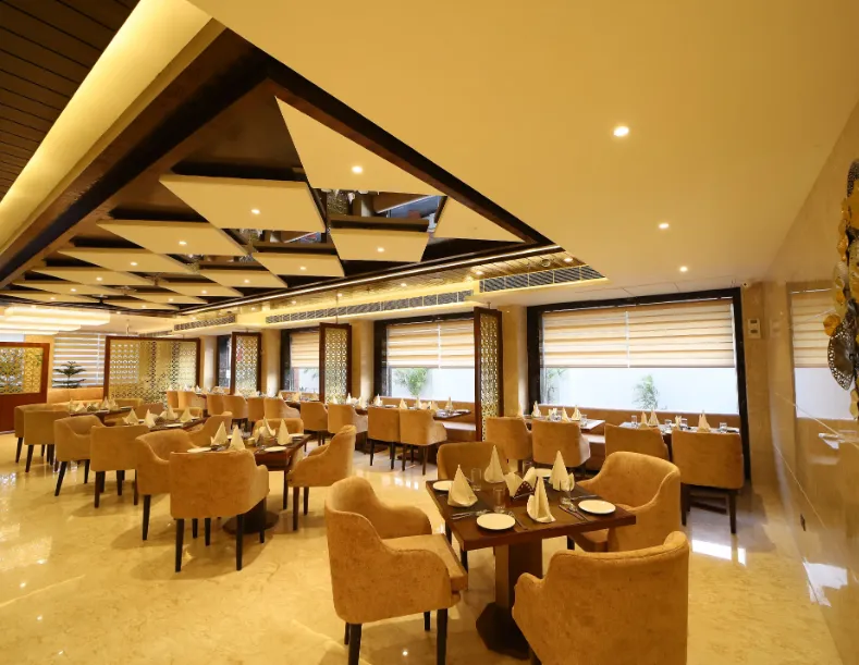 Restaurant at Hotel DVIJ Inn Jaipur showing dining tables and interior seating layout