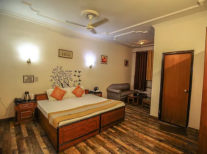 Deluxe room at Hotel Goverdhan Palace Mathura featuring spacious layout and seating area