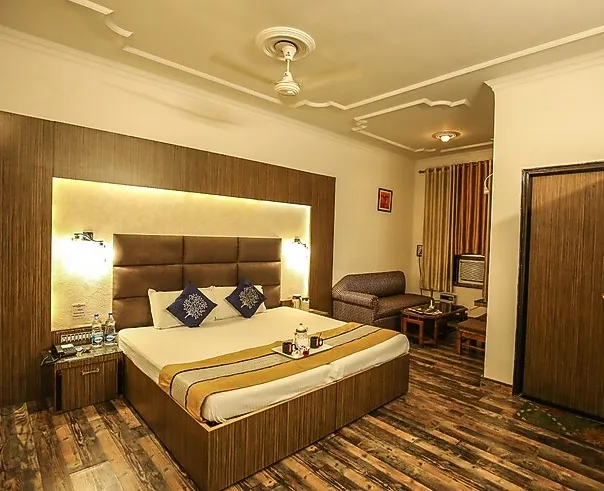 Deluxe super ac room at Hotel Goverdhan Palace Mathura featuring spacious layout and seating area