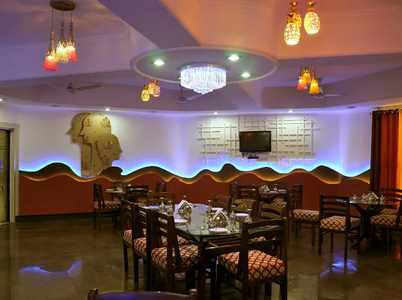 Restaurant at Hotel Goverdhan Palace Mathura with dining tables and well-lit interiors