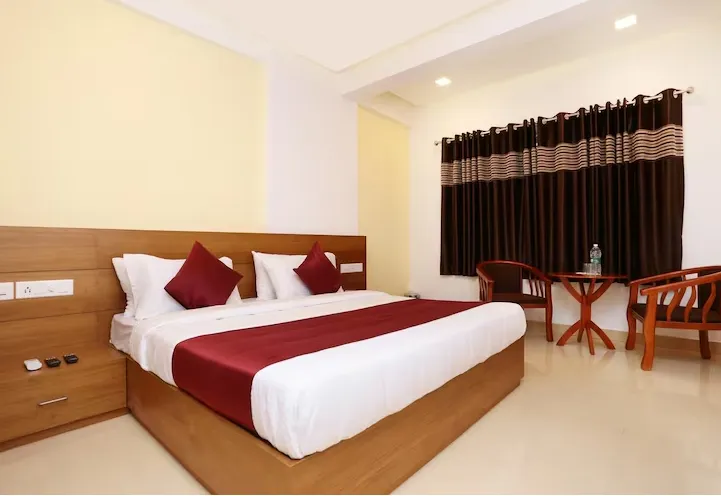 Super Deluxe room at Hotel Neelkanth Ayodhya showing larger layout with seating area and indoor lighting