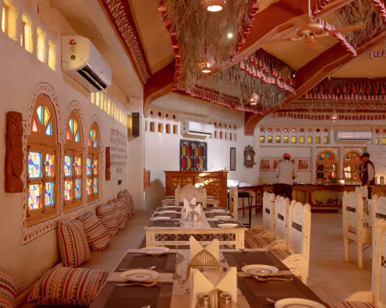 Restaurant at Hotel Nirali Dhani Jodhpur showing dining tables and interior décor