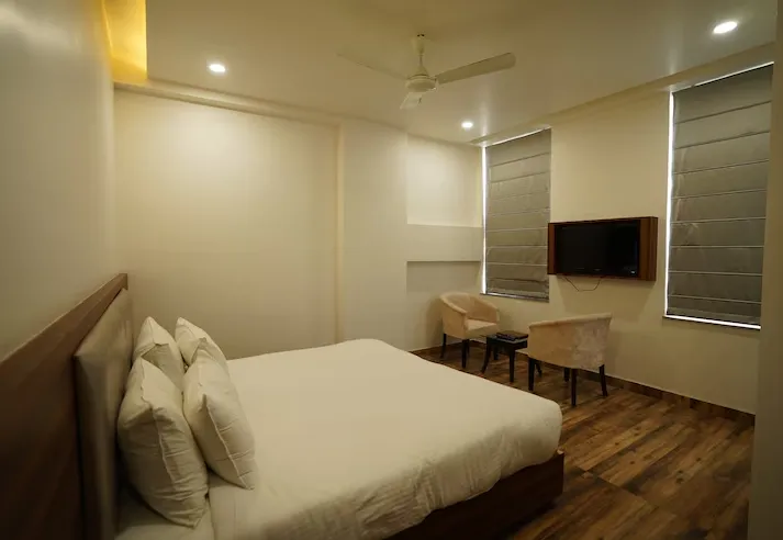 Deluxe room at Hotel Regal Jaipur with double bed setup and neatly arranged furniture