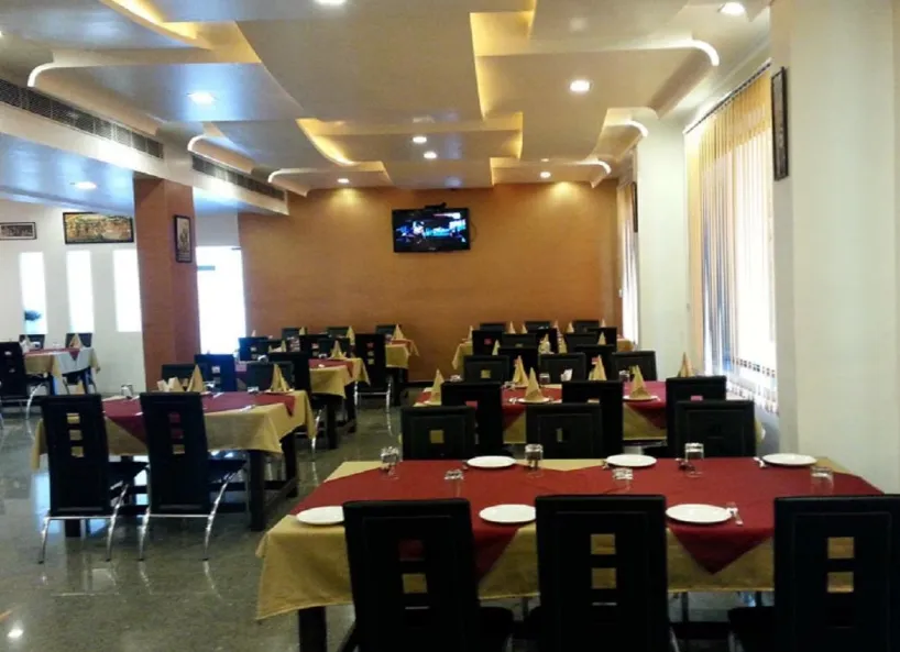 Restaurant at Hotel Royal View Jaipur featuring dining tables and indoor lighting