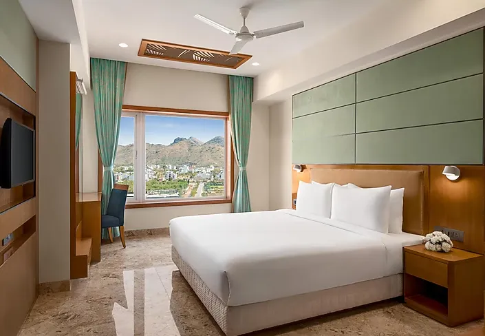 Deluxe room at Howard Johnson by Wyndham Udaipur showing spacious bed and window lighting