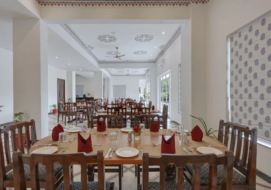 Restaurant interior at Jag Aravali Udaipur showing dining tables, chair setup, and serving area