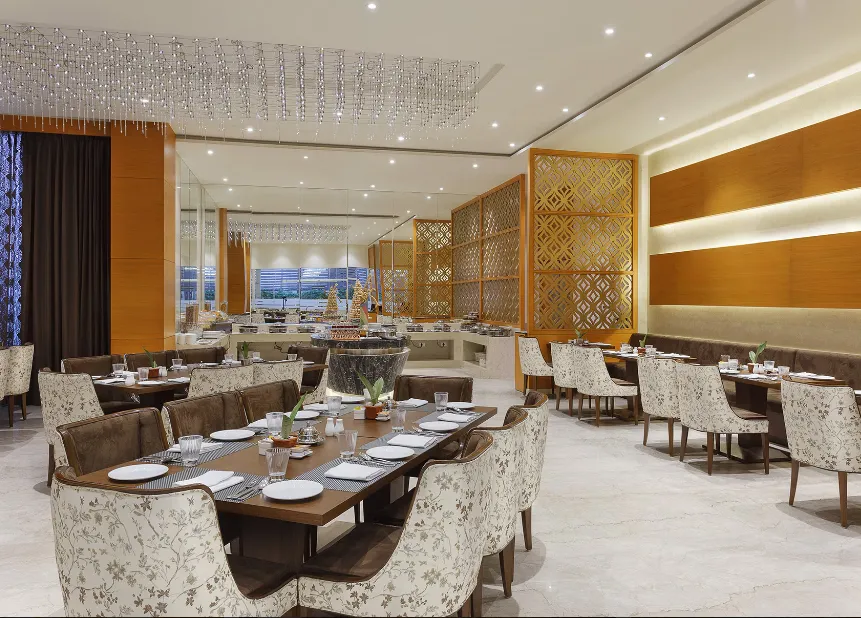 Restaurant at Nataraj Sarovar Portico-Jhansi Gorakhpur with dining tables, chairs, and well-lit interiors