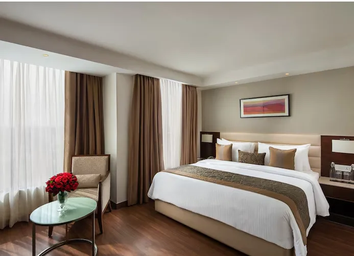 Deluxe room at Nirvana Sarovar Portico Gorakhpur featuring larger layout, seating area, and contemporary interiors