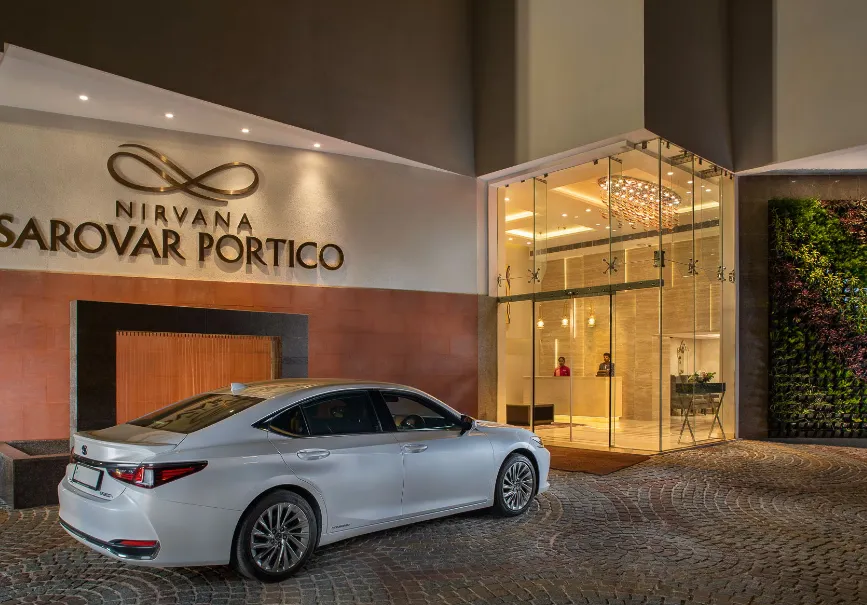 Front entrance of Nirvana Sarovar Portico Gorakhpur showing modern façade and well-lit arrival driveway