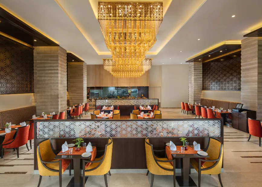 In-house restaurant at Nirvana Sarovar Portico Gorakhpur displaying dining tables and clean contemporary setup