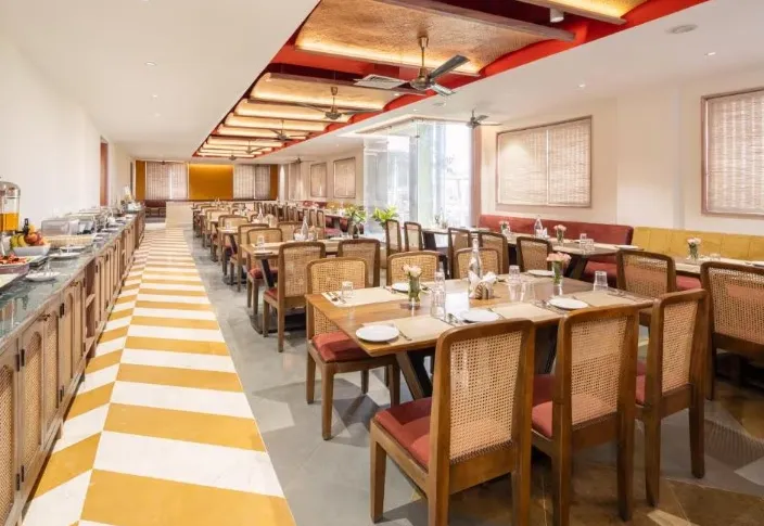Restaurant at Raasvan Vrindavan AM Hotel Kollection Vrindavan featuring dining tables and interior layout
