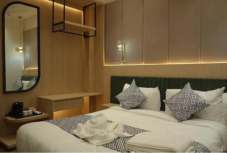 Deluxe room at Raam Leela Hotel Ayodhya featuring larger space, seating area, and simple decor