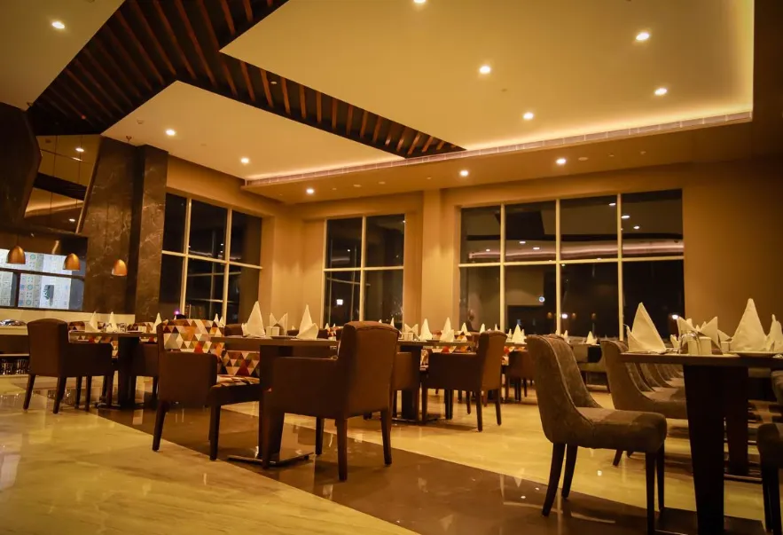 Restaurant at Ramada By Wyndham Aligarh GT Road Agra with arranged dining tables, buffet counters, and bright interiors