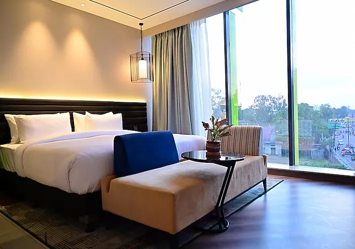 Deluxe room at Ramada Encore by Wyndham Bareilly Civil Lines showing a larger layout, seating area, and contemporary interiors