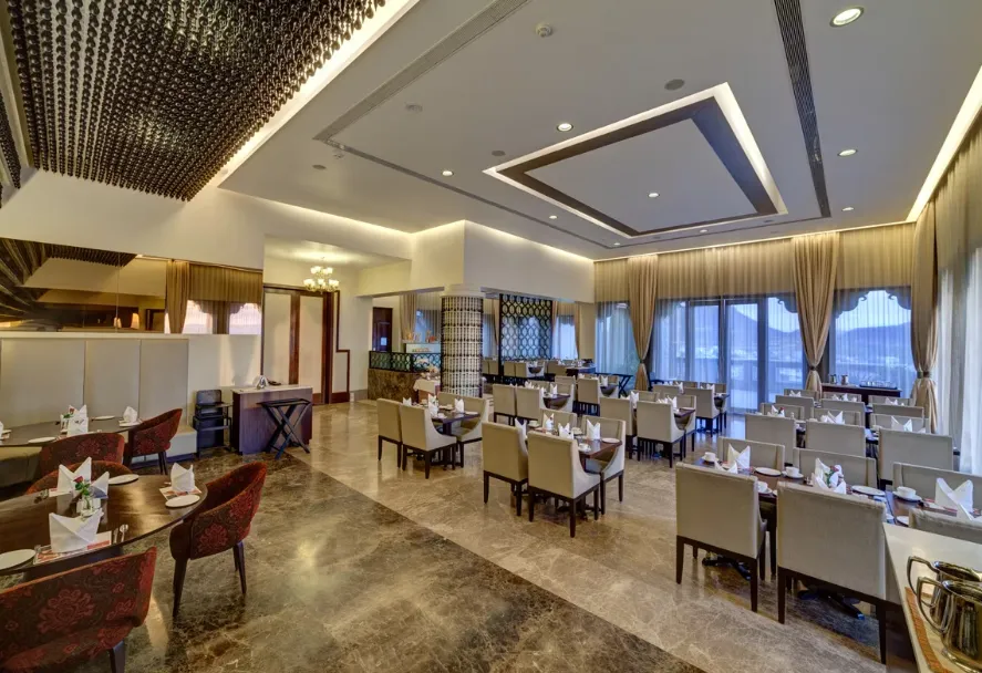 Restaurant at Ramada by Wyndham Udaipur Resort and Spa Udaipur showing dining tables and interior layout