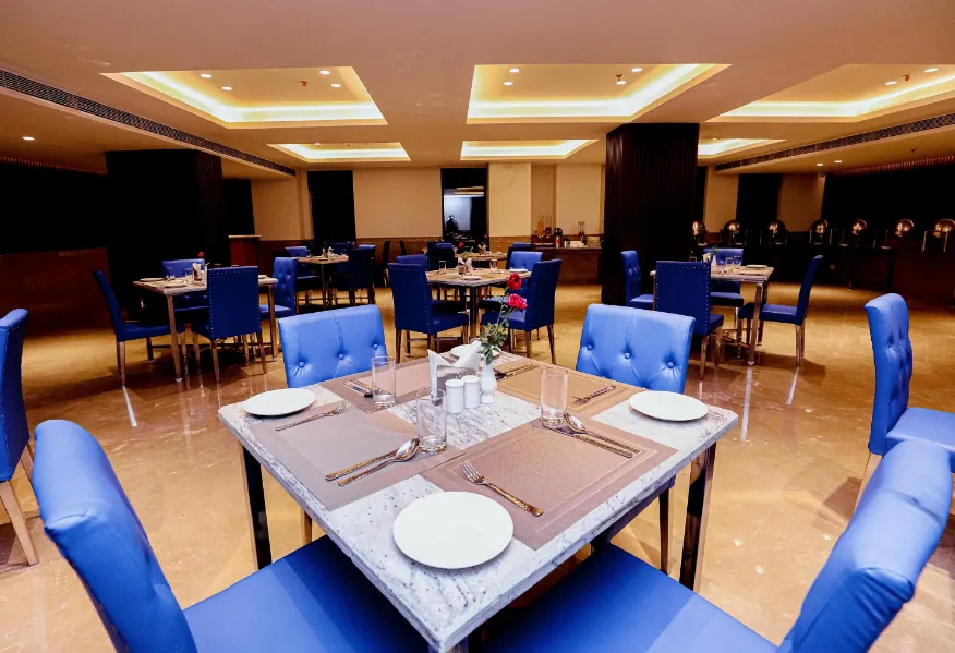 In-house restaurant at Regenta Gulab Kothi Varanasi with dining tables, chairs, and organized service layout
