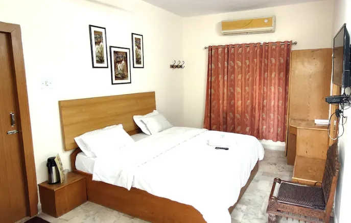 Deluxe AC room at Rising Sun Retreat Mount Abu with double bed, side tables, and soft lighting