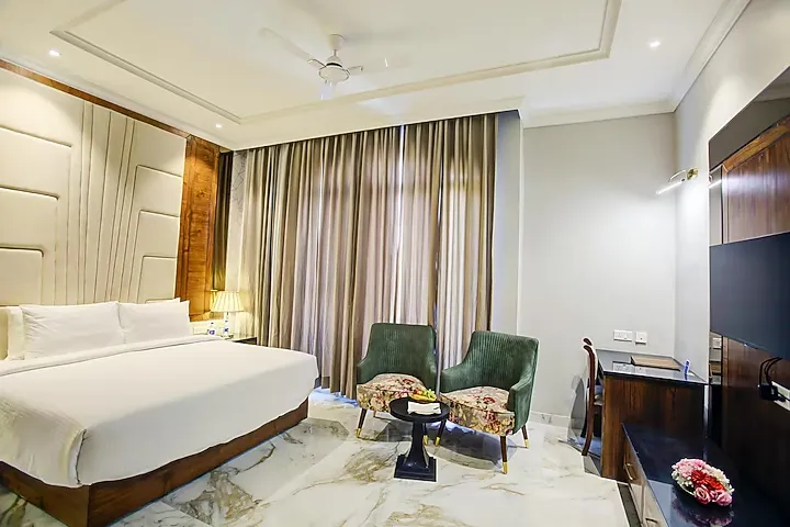 Deluxe room at Sarovar Portico Saharanpur showing larger layout with seating and workspace