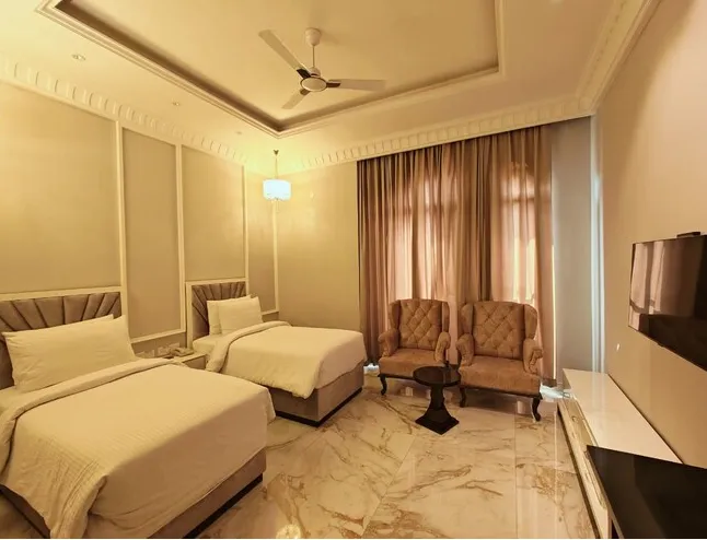 Deluxe room at Sarovar Portico Saharanpur showing larger layout with seating and workspace