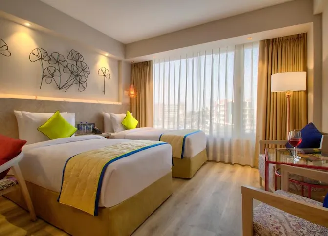 Deluxe room interior at Sarovar Premiere Jaipur with spacious bed, work desk, and neutral décor