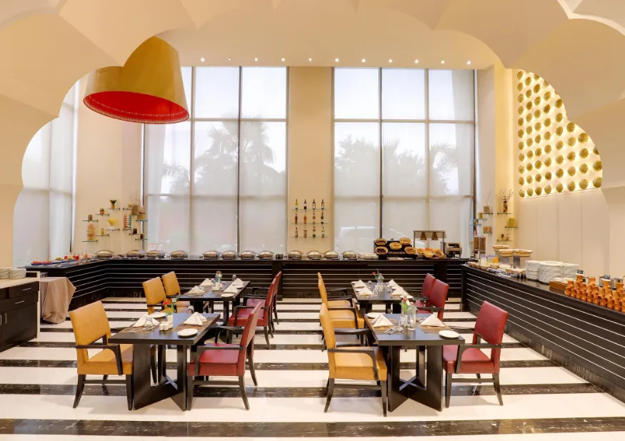 Restaurant at Saura Hotel, Agra - A Club Mahindra Associate showing dining tables and interior arrangement