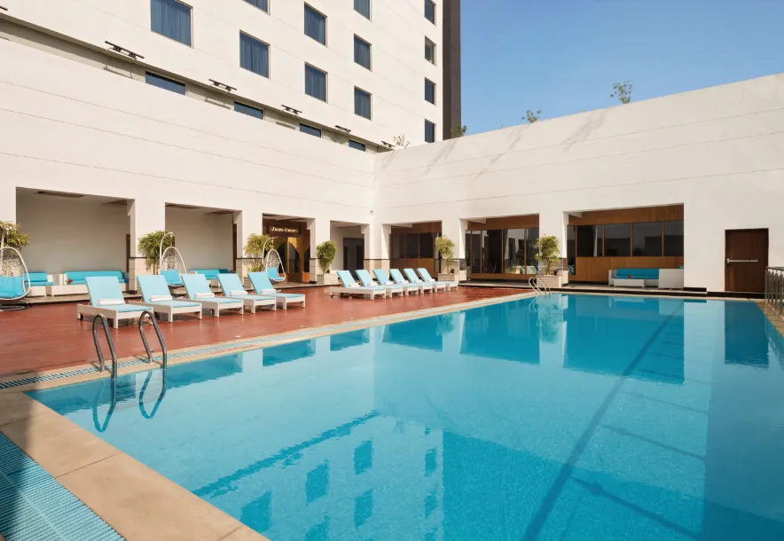 Swimming pool at Saura Hotel, Agra - A Club Mahindra Associate showing poolside area and surrounding deck