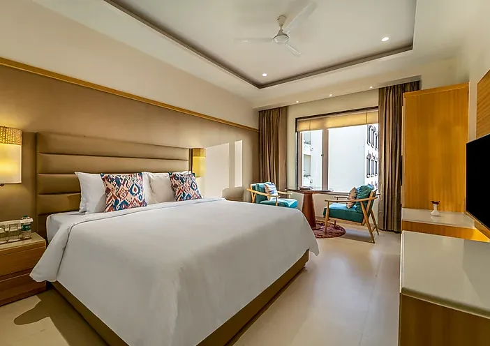 Deluxe room at Shyama Sarovar Portico Orai showing added space and seating arrangement