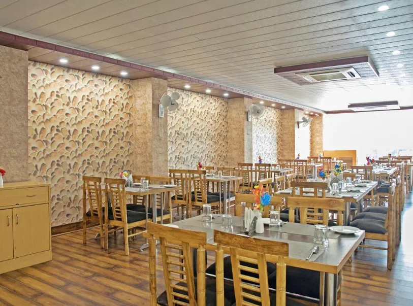 Restaurant at Spring Sky by ShriGo Hotels Mughalsarai featuring dining tables and interior setup