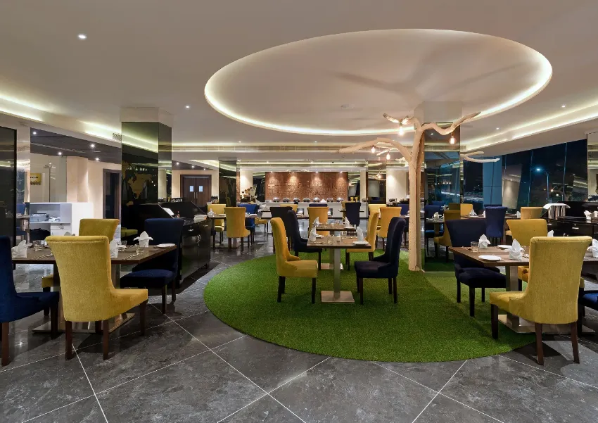 Restaurant area at The Fern Residency Udaipur with dining tables, lighting fixtures, and service layout