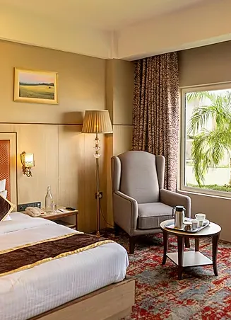 Suite room at The Lalita Grand Mathura with separate seating area and spacious interior
